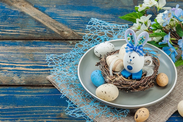 Table de Pâques avec des œufs, un nid d'oiseau et une branche en fleurs