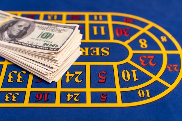 Table de pari de roulette dans le casino avec une grosse liasse d'argent dessus