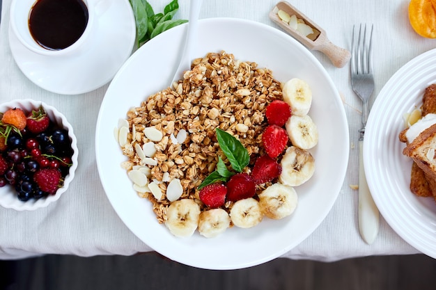 Table de petit-déjeuner continental frais et lumineux, variété de repas sains en abondance, céréales croustillantes, pain doré, fruits, limonade, café, croissant sur table servi