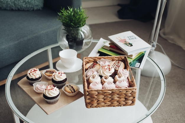 Une table de petit-déjeuner avec une tasse de café, des bonbons, des guimauves et des biscuits