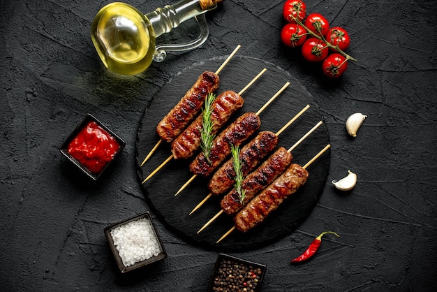 Une table en pierre noire avec une assiette de nourriture avec un kebab dessus.