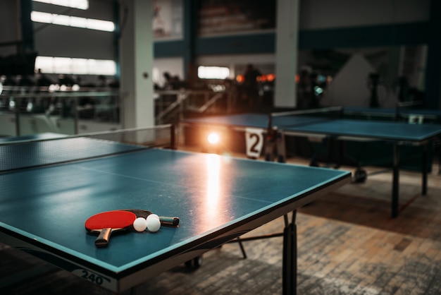 Table de ping-pong avec raquettes et balles dans une salle de sport