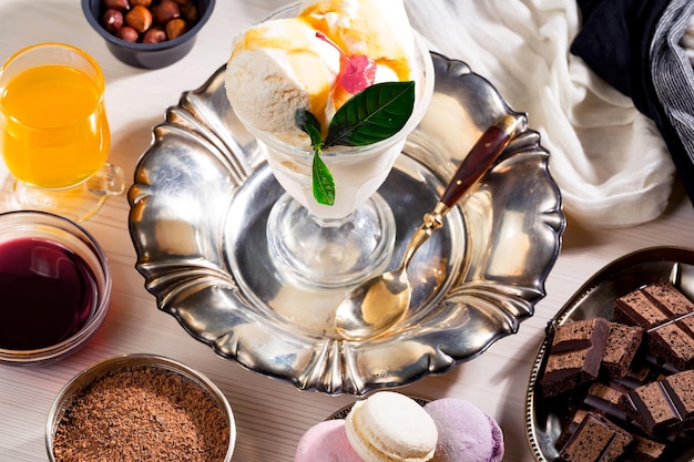 Une table pleine de desserts dont un verre de glace et un bol de chocolats.