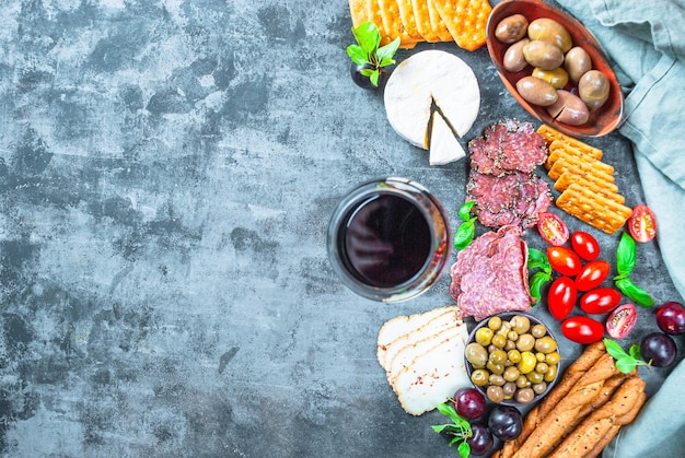 Une table pleine de fromages, de viandes et de légumes.