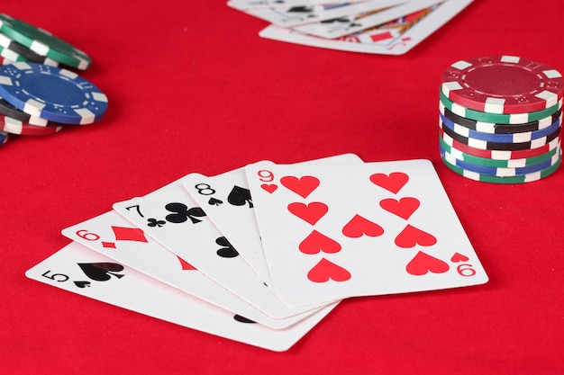 La table de poker rouge avec des cartes à jouer La combinaison de quinte