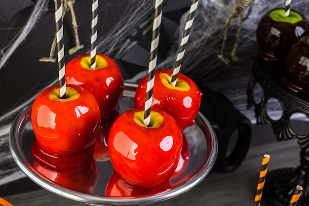 Table avec des pommes de bonbons colorées pour la fête d'Halloween.