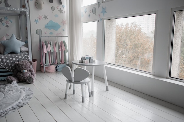 Table pour enfants avec chaises près de la fenêtre