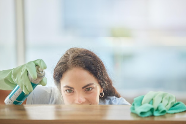 Table de pulvérisation ou femme nettoyant les surfaces des meubles avec un produit pour les bactéries salissantes ou sales dans le salon de la maison Travail de service de nettoyage ou nettoyant avec une bouteille de détergent liquide essuie le bois humide ou poussiéreux