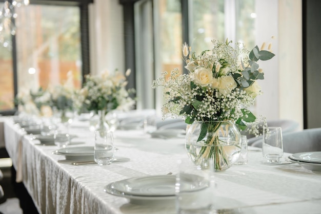 Table de réception de mariage au restaurant décorée de bougies blanches et de fleurs