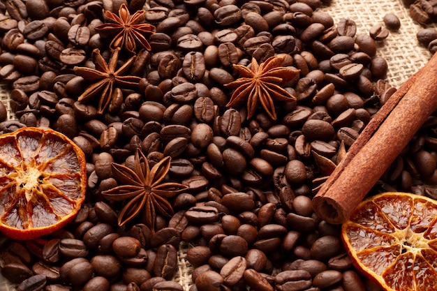 Une table recouverte de grains de café à la cannelle, d&#39;étoiles d&#39;anis et d&#39;orange séchée.