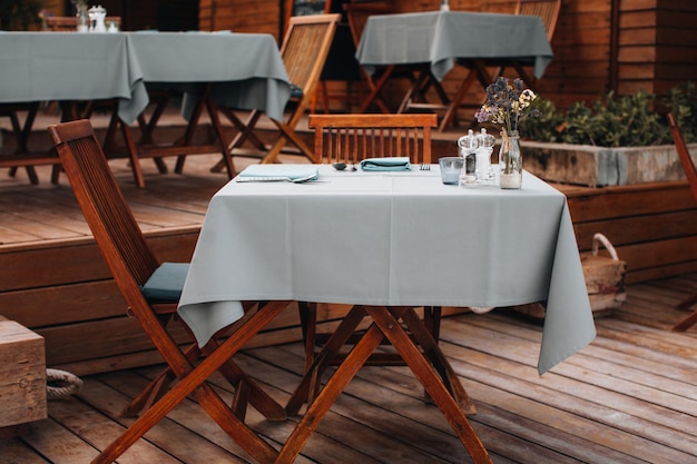 Table recouverte de nappes et chaises en bois dans un restaurant en plein air d'été