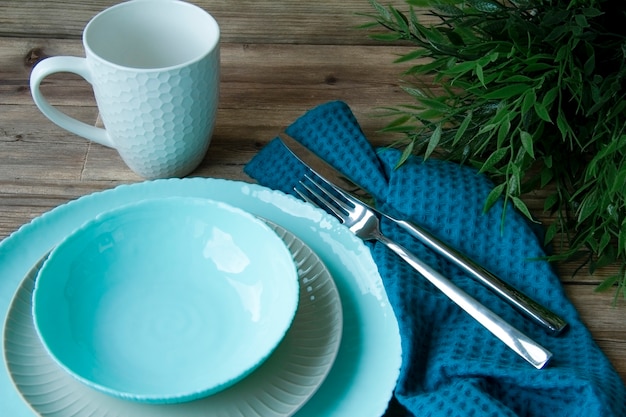 à une table remplie d'assiettes, d'une tasse et de couverts