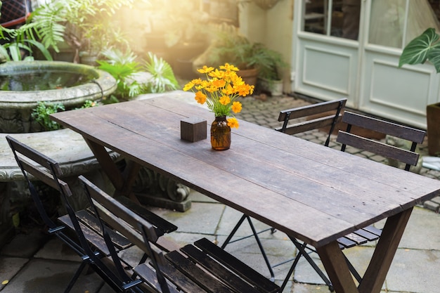 Table De Repas En Bois Dans Le Jardin Extérieur Orné De Vases à Fleurs Jaunes.