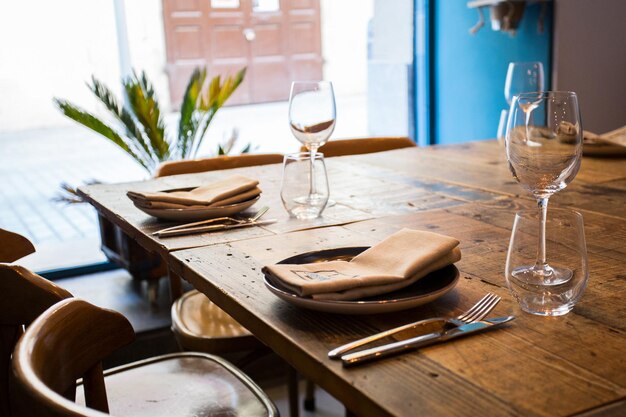 Photo table de restaurant élégante avec couverts, vaisselle et verres.