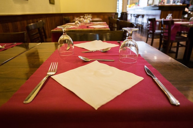 Table de restaurant élégante avec couverts, vaisselle et verres.