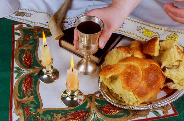 Photo table de réveillon de shabbat avec pain challah non couvert, bougies du sabbat