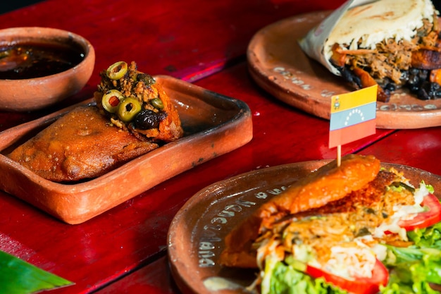 Table rustique avec un plat vénézuélien typique, empanada et arepa. Friture.