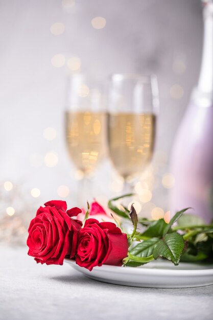 Table de la Saint-Valentin, roses rouges et verres de champagne sur fond de béton. Carte de voeux de la Saint-Valentin - Image