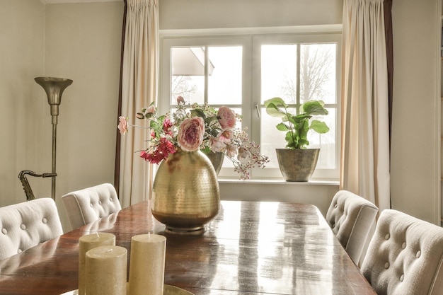 Une table de salle à manger avec des fleurs et une fenêtre