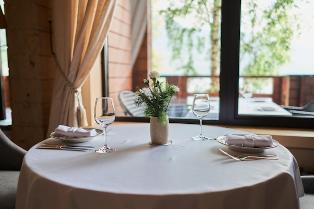 Table servie avec des bougies allumées et des fleurs fraîches pour un dîner de fête