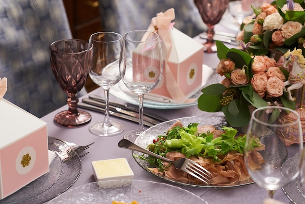 Table servie festive avec fleurs et décor aux couleurs pastel pour les invités sur une assiette