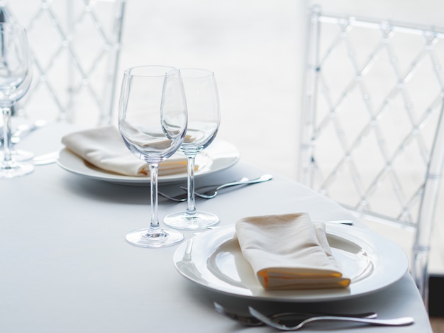 Table servie pour le banquet avec couverts, verres à vin et serviettes.