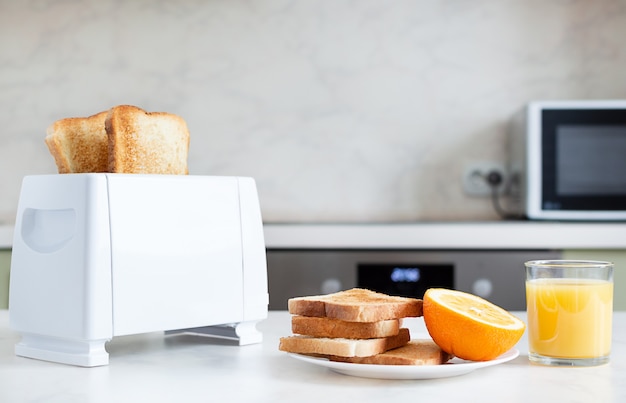 Table servie pour le petit déjeuner avec toasts, fruits, jus d'orange.