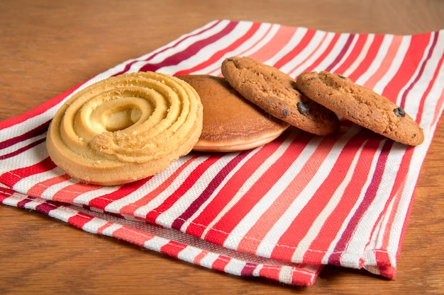 Sur la table sur une serviette rouge dans les gâteaux rayés est au café.