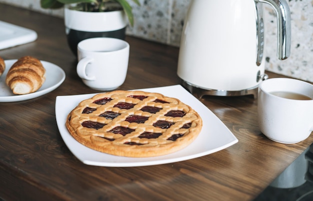 Table de surface de travail avec pâtisseries et bouilloire dans la cuisine à la maison