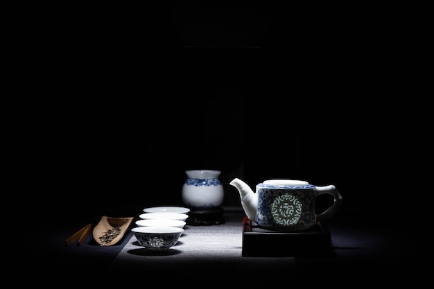 Une table avec une théière et des tasses avec un motif blanc et bleu dessus.