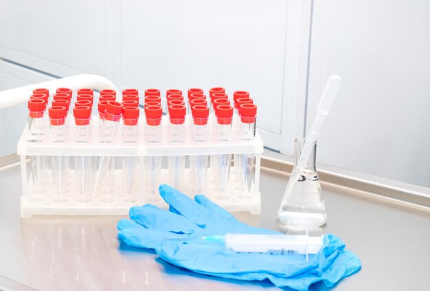 Sur la table de traitement un rack avec tubes à essai pour analyse gants seringue