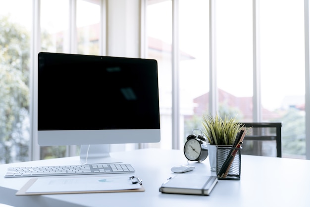 Table de travail de bureau blanche moderne avec ordinateur portable et stationnaire dans le bureau à domicile