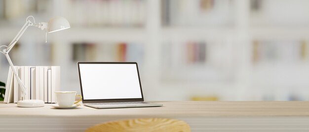 Table de travail avec décor de maquette d'ordinateur portable et espace vide sur une bibliothèque floue en arrière-plan rendu 3d