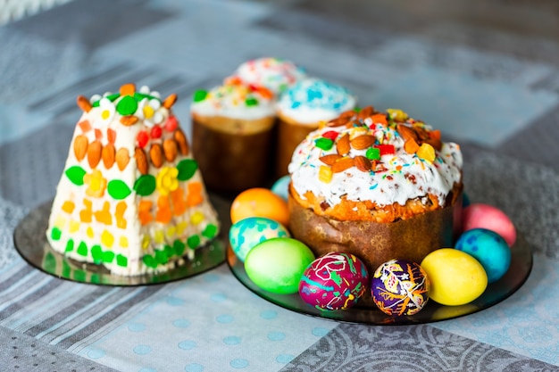 Table de vacances de Pâques traditionnelle servie avec un gâteau de Pâques fait maison et des œufs peints