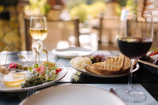 Une table avec un verre de vin et une assiette de nourriture dessus