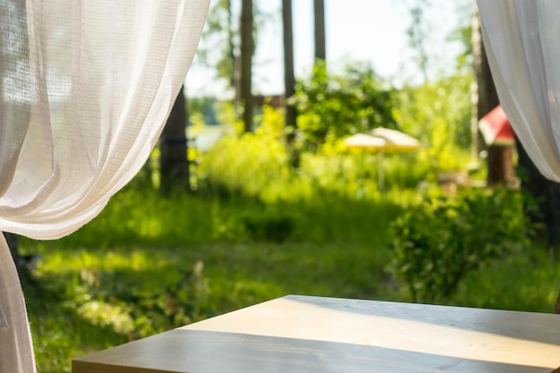 Table vide et fond clair de café de jardin flou. modèle d'affichage du produit. Présentation de l'entreprise