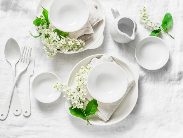 Table vide servie avec des serviettes de fleurs de vaisselle blanche sur fond blanc vue de dessus Maison confortable