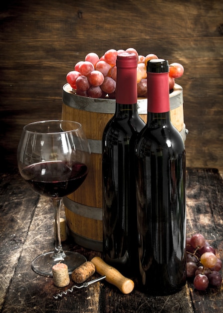 Table à vin. Une barrique de vin rouge et de raisins frais. Sur une table en bois.