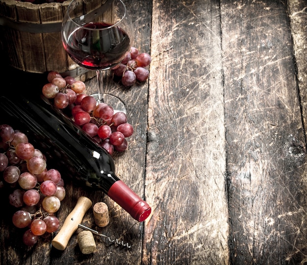 Table à vin. Vin rouge avec des verres avec des raisins. Sur une table en bois.