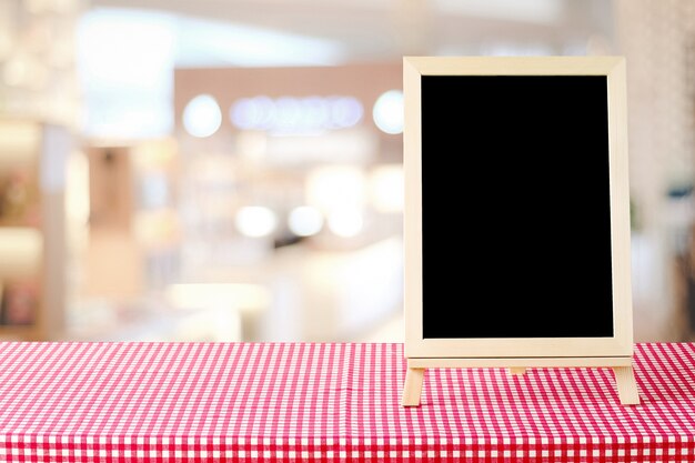 Tableau blanc debout sur une nappe rouge et blanche