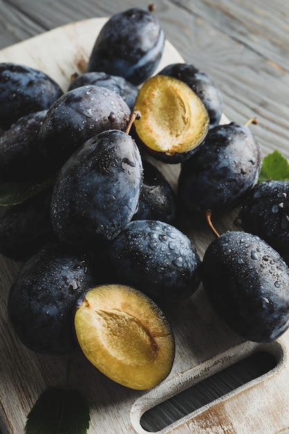 Tableau blanc avec des prunes fraîches sur bois