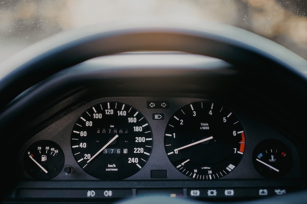 Photo tableau de bord de voiture rétro vintage avec compteur de vitesse analogique, tachymètre et compteur kilométrique.