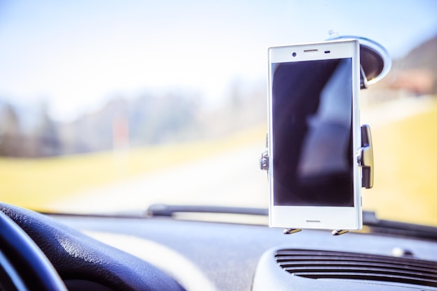 Tableau de bord de voiture avec smartphone utilisé comme appareil de navigation journée lumineuse et ensoleillée