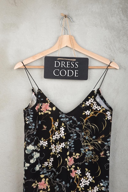 Tableau de concept de mode avec code vestimentaire texte et belle robe à motif floral sur un cintre