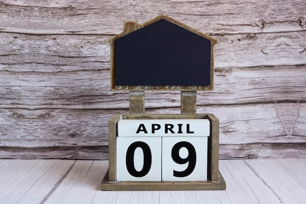 Photo tableau à craie avec la date d'avril sur un cube blanc sur une table en bois