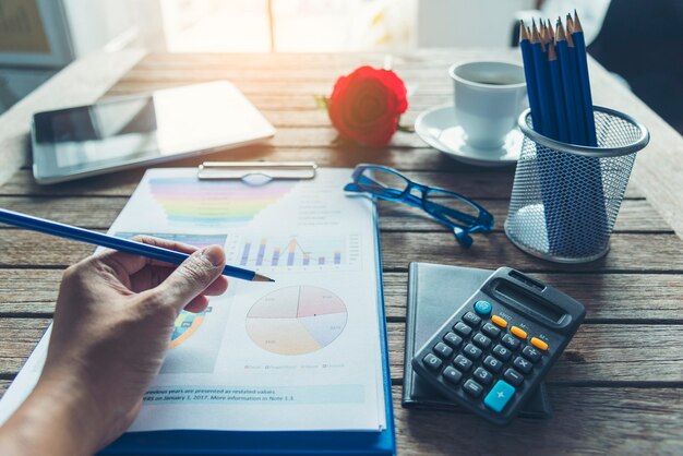 Tableau et graphique de document financier d'entreprise d'ordinateur portable de bureau sur la table en bois avec la tasse de café