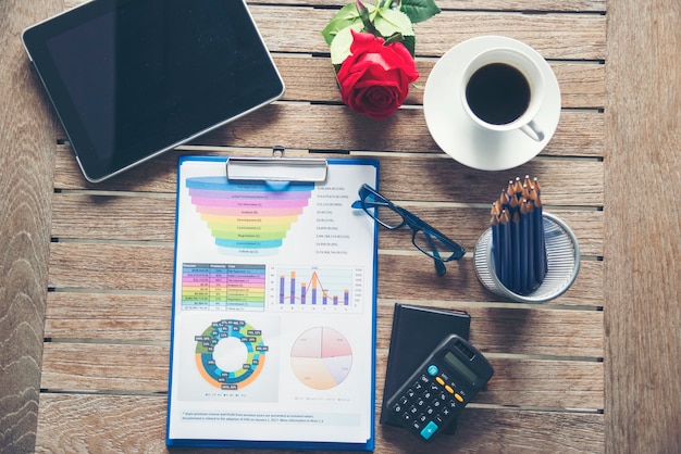 Tableau et graphique de document financier d'entreprise d'ordinateur portable de bureau sur la table en bois avec la tasse de café