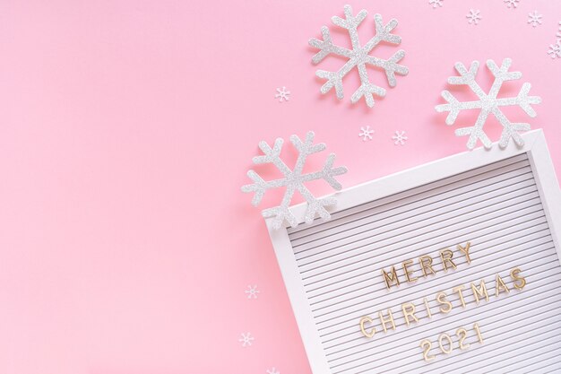 Tableau à lettres avec voeux joyeux Noël, flocon de neige décoratif sur fond girly pastel rose