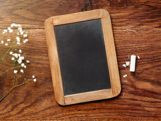 Tableau noir et craie sur table en bois.