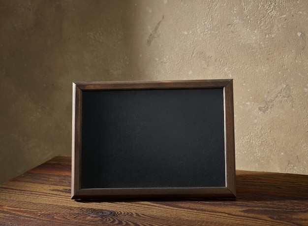 Tableau noir dans un cadre en bois sur une table à l'intérieur de la pièce